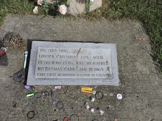This stone marks where Louiza Fox was murdered, about a mile away from her grave in Salem Cemetery. The marker is on Starkey Road, and many visitors have left coins or other tokens at the site.